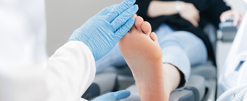 A close-up of a clinician examining a patient's ankle, representing specialist foot and ankle assessment and diagnosis in Singapore.