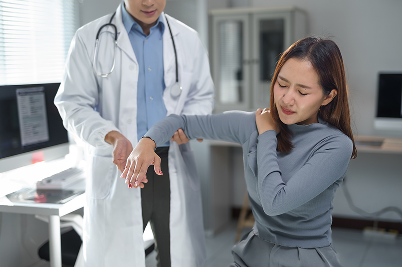A patient getting their arm and shoulder joint checked by a doctor